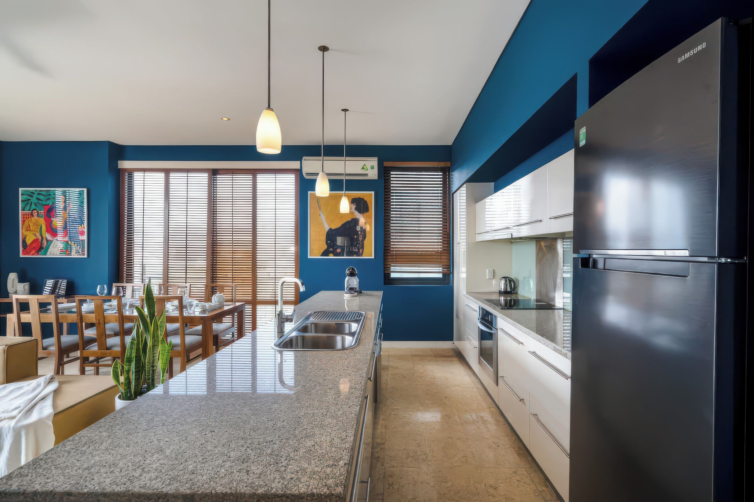 Eine moderne Küche mit Edelstahl-Kühlschrank, Granit-Arbeitsplatten und einem Essbereich mit Holztisch.
