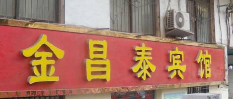 A building with a red and yellow sign that reads '金昌泰宾馆' (Jin Chang Tai Inn).