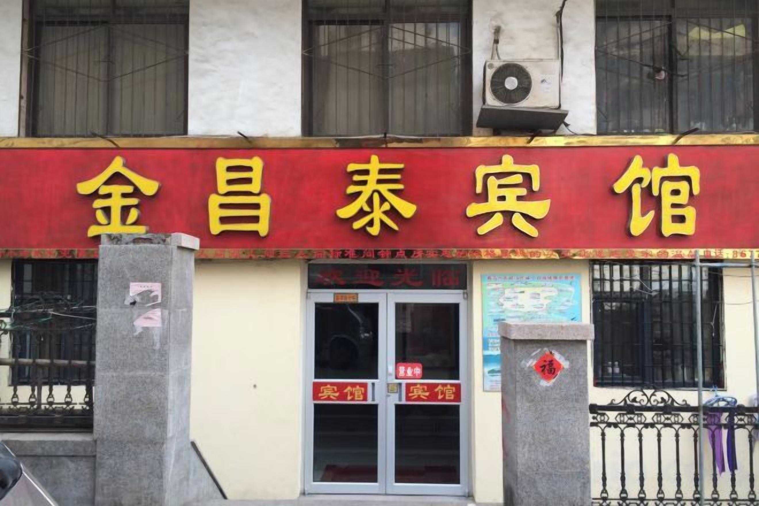A building with a red and yellow sign that reads '金昌泰宾馆'.