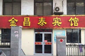 A building with a red and yellow sign that reads '金昌泰宾馆'. - Jinchangtai Hotel (Qingdao)