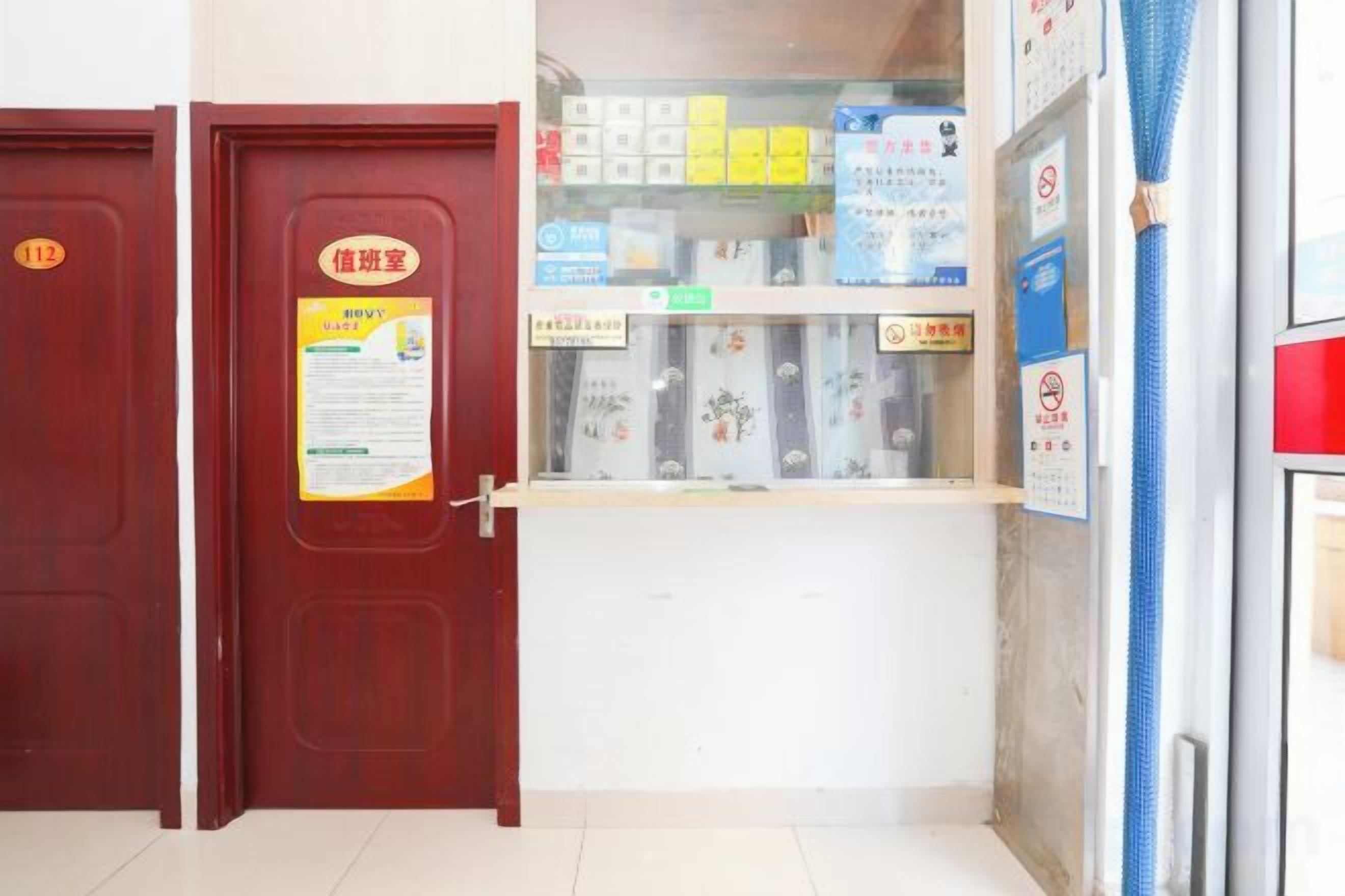 Une pièce avec une porte, un petit comptoir où sont exposés divers objets, et un objet bleu accroché au mur.