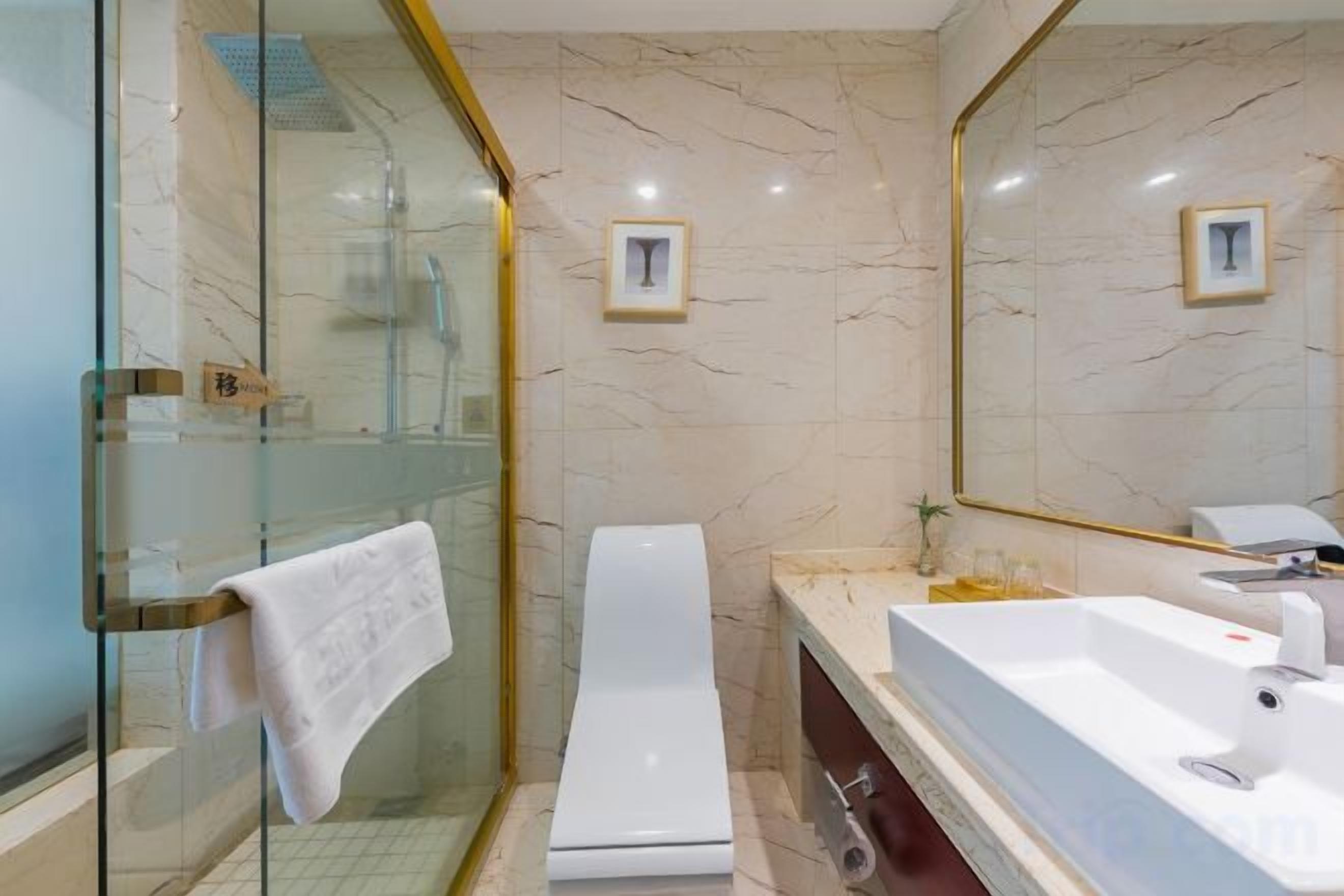 A bathroom with a glass-enclosed shower, a white toilet, and a large sink with a mirror.