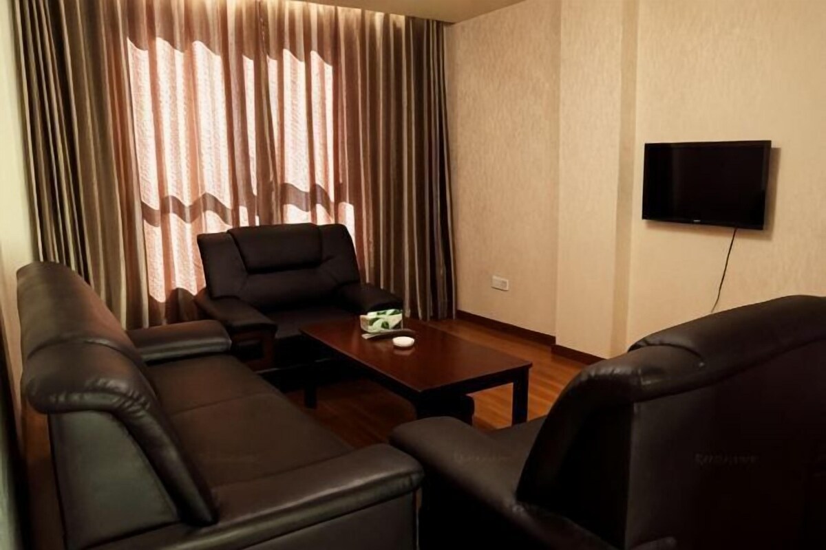 Olohuoneessa on sohvaryhmä, sohvapöytä ja seinälle asennettu televisio.