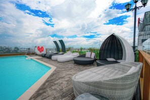 A rooftop pool area with lounge chairs and a view of the city skyline. - Salute de Léman - Luxury Apartment District 3 (Ho Chi Minh City)