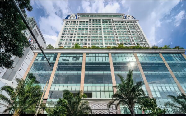Stunning high-rise building with a grid-like facade and lush green surroundings.