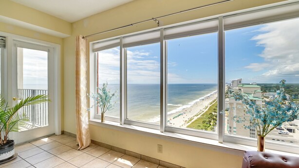 Varanda com vista para a praia e o horizonte urbano.