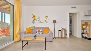 A modern living room with a sofa, coffee table, and a bookshelf. - Apartment 'New Casa Tiberio' with Shared Pool, Wi-Fi and Air Conditioning (Lazise)