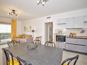 Un appartamento moderno con zona pranzo, cucina e soggiorno.