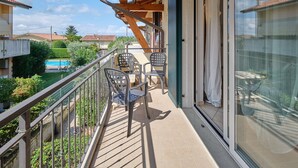 A balcony with a wooden ceiling, metal railings, and a glass door leading to a room. - Apartment 'Madonnina  In Lazise' with Shared Pool, Wi-Fi and Air Conditioning (Lazise)