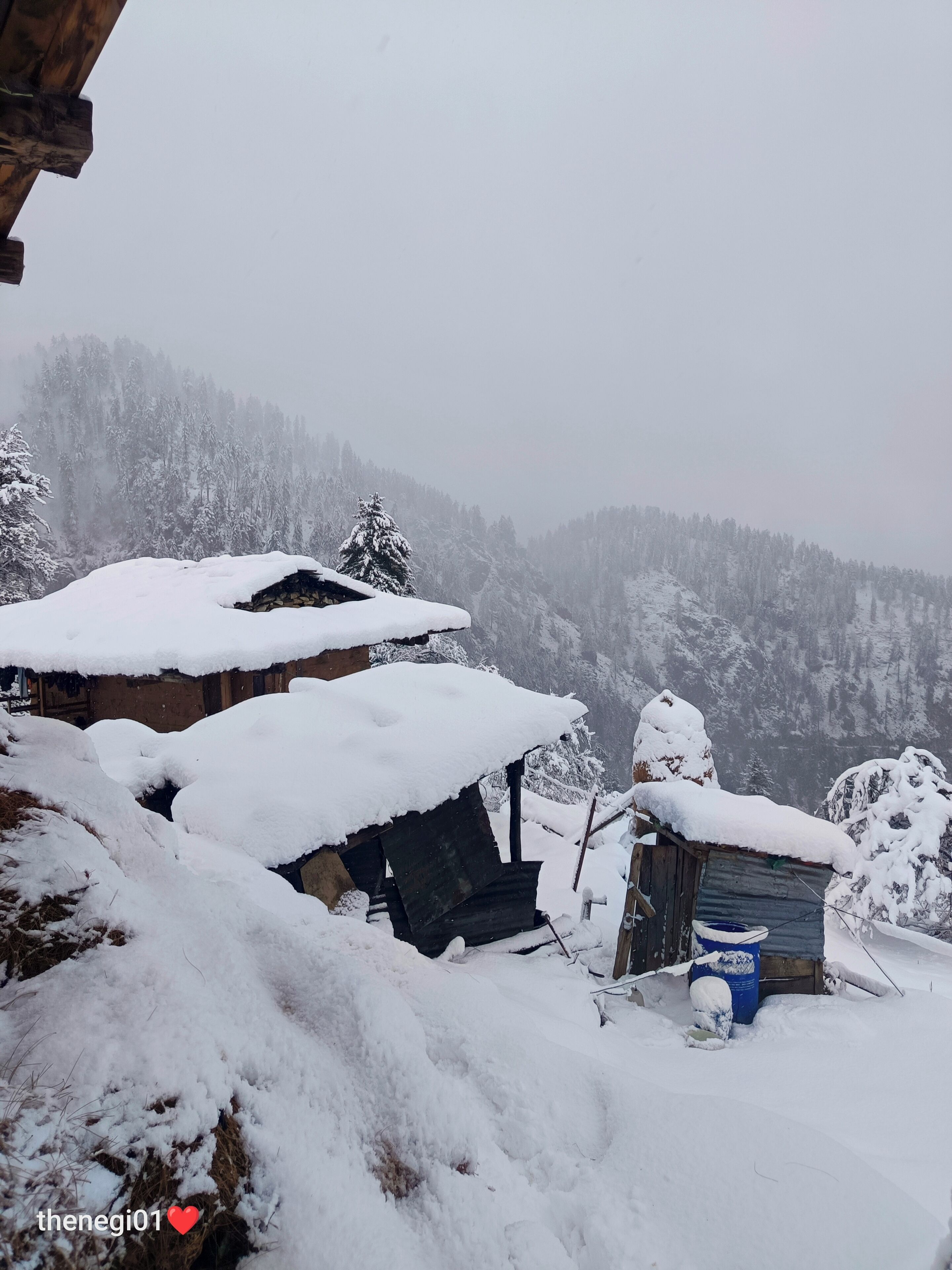 A snowy village with rustic buildings and a mountainous backdrop.