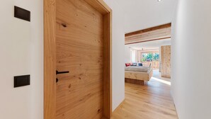 A wooden door with a handle, a white wall, and a wooden floor. - Studio Apartment 'Gardena' with Mountain View, Shared Garden and Wi-Fi (Fié allo Sciliar)