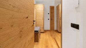 A hallway with wooden walls, a bench, and a door. - Studio Apartment 'Gardena' with Mountain View, Shared Garden and Wi-Fi (Fié allo Sciliar)