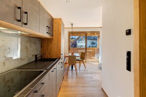 Una cocina moderna con una isla central, armarios de madera y vistas al comedor.