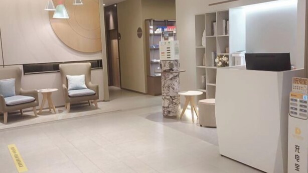 A modern hotel lobby with seating areas, a reception desk, and a self-service kiosk. - Yujiagui Hostel (Shanghai)