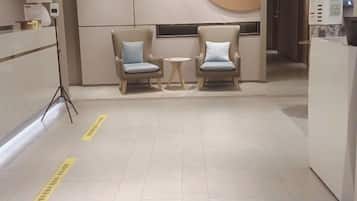 A reception area with two chairs, a small table, and a counter.