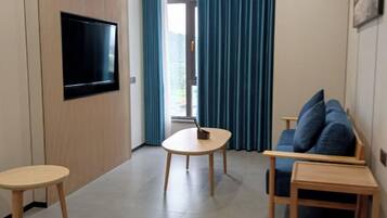 Suite familiar, 2 habitaciones, para no fumadores, vista a la ciudad | Área de sala de estar | Televisión