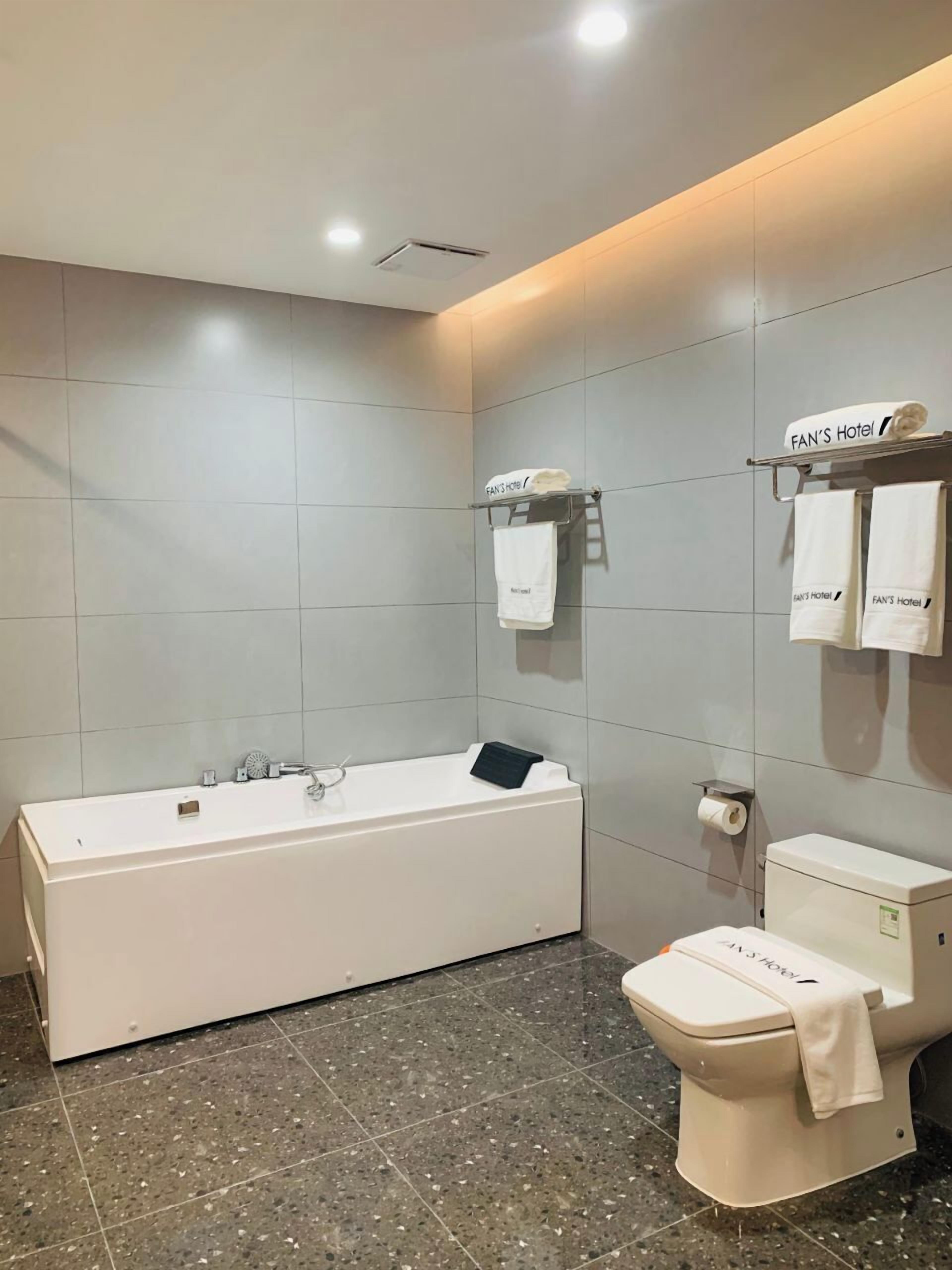 Un bagno moderno con vasca, water e porta asciugamani.