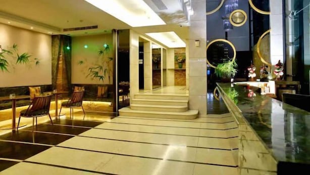 A modern lobby with a checkered floor, seating area, and a staircase leading to another level. - Cui Zhu Hotel (Shenzhen)