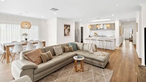 Un salon moderne avec un canapé, une table basse et un coin repas.