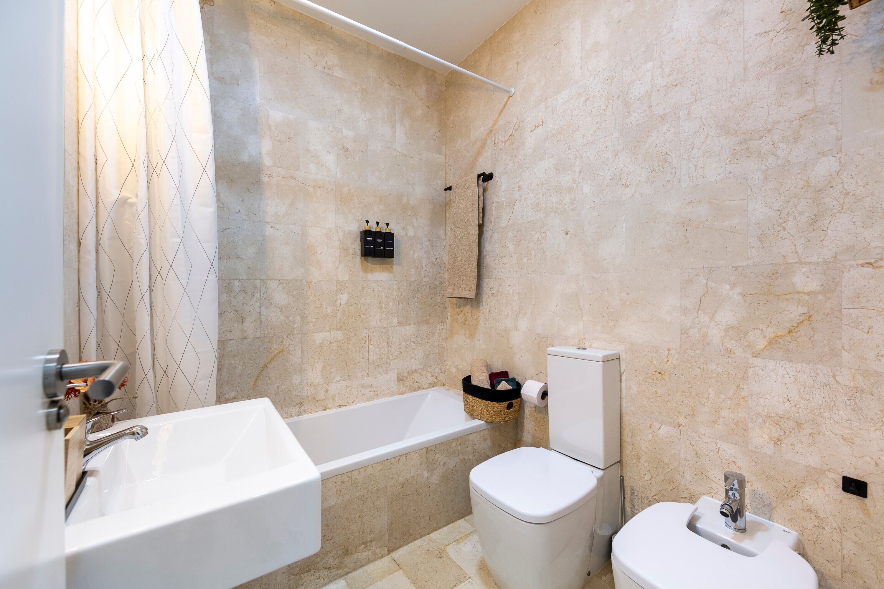 A bathroom with a bathtub, toilet, and sink.
