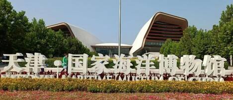 A modern building with a unique architectural design, surrounded by a well-maintained garden with colorful flowers.