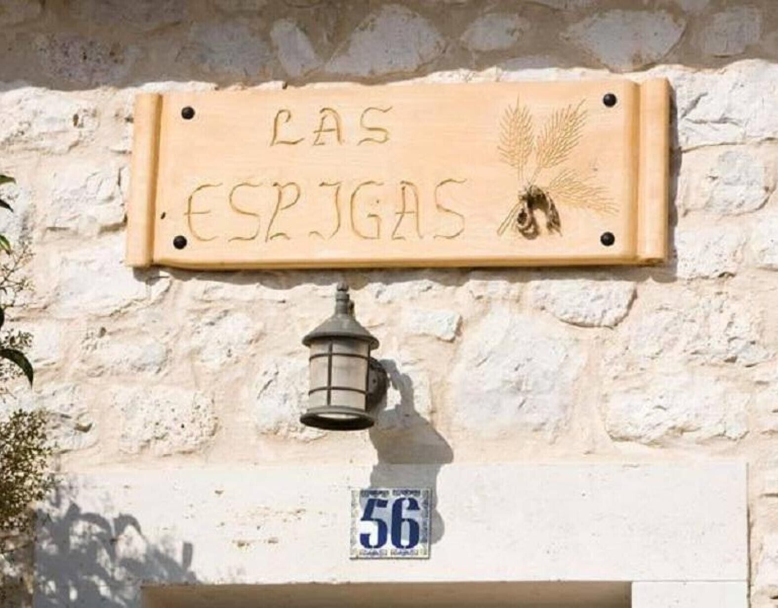 Une enseigne en bois portant l’inscription « LAS ESPIGAS » et une lanterne placée en dessous.