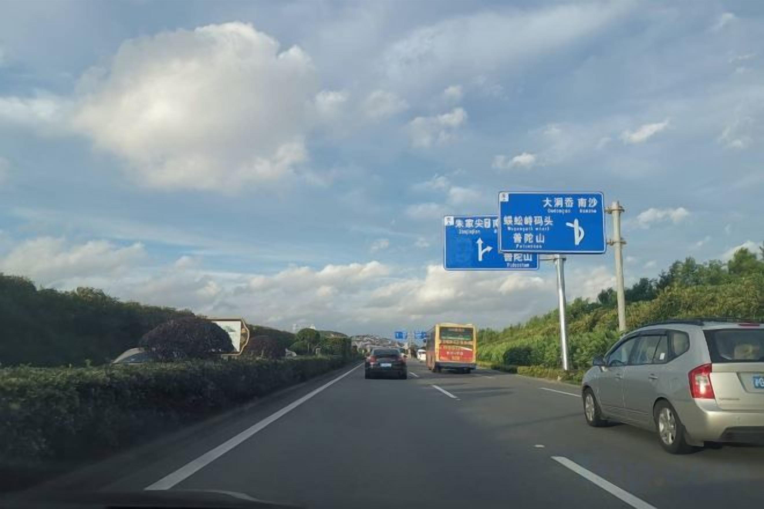 Une autoroute avec des panneaux de signalisation et des véhicules.
