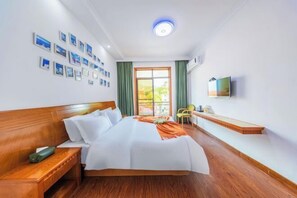 Een hotelkamer met een groot bed, een nachtkastje, een stoel, een televisie en een raam met gordijnen.