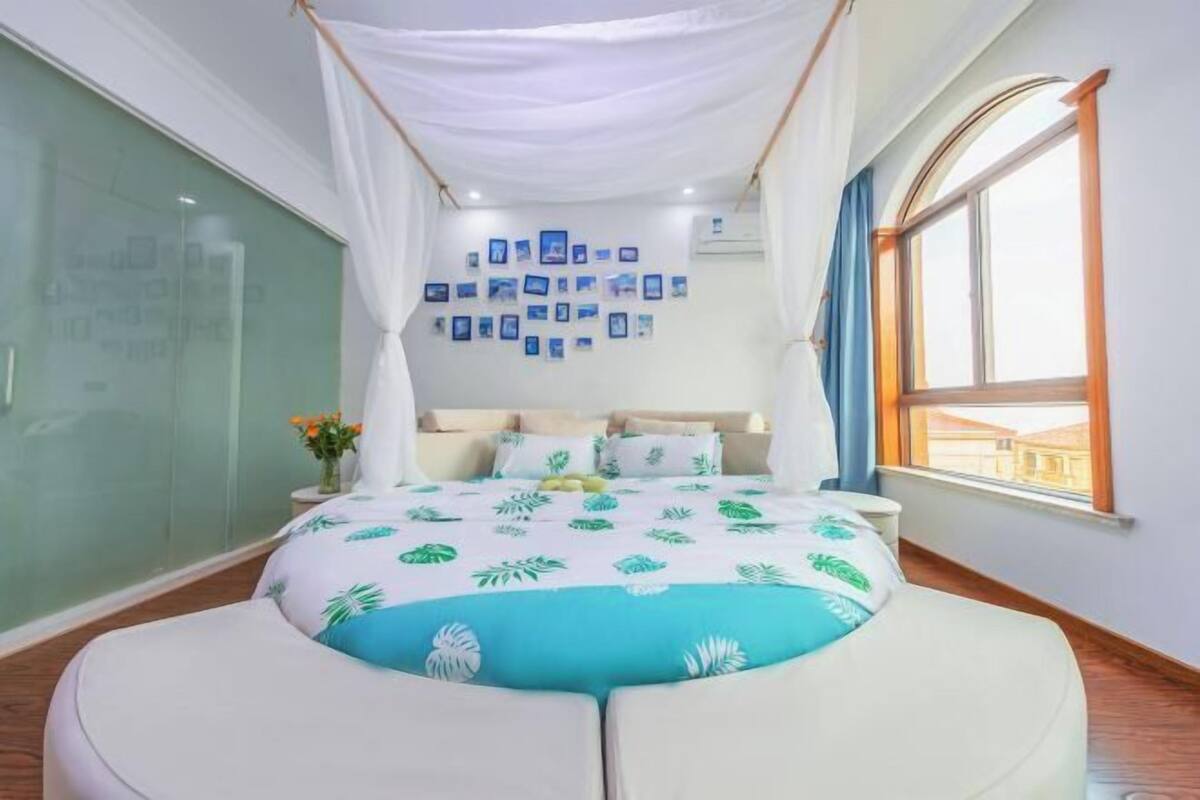 Une chambre à coucher avec un lit, une fenêtre et un mur décoré de tableaux.