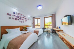 A hotel room with two beds, a desk, a chair, a TV, and a wall with photos. - Zhujiajian Island Time Homestay (Zhoushan)