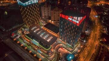 A modern building with a unique geometric design, featuring a central courtyard with a patterned floor and surrounding structures.