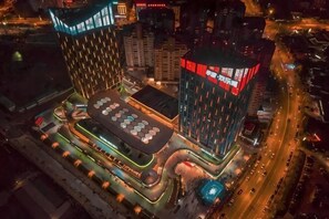 A modern building with a unique geometric design, featuring a central courtyard with a patterned floor and surrounding structures. - Xianhong Business Hotel (Wanning High Speed Railway Station) (Wanning)