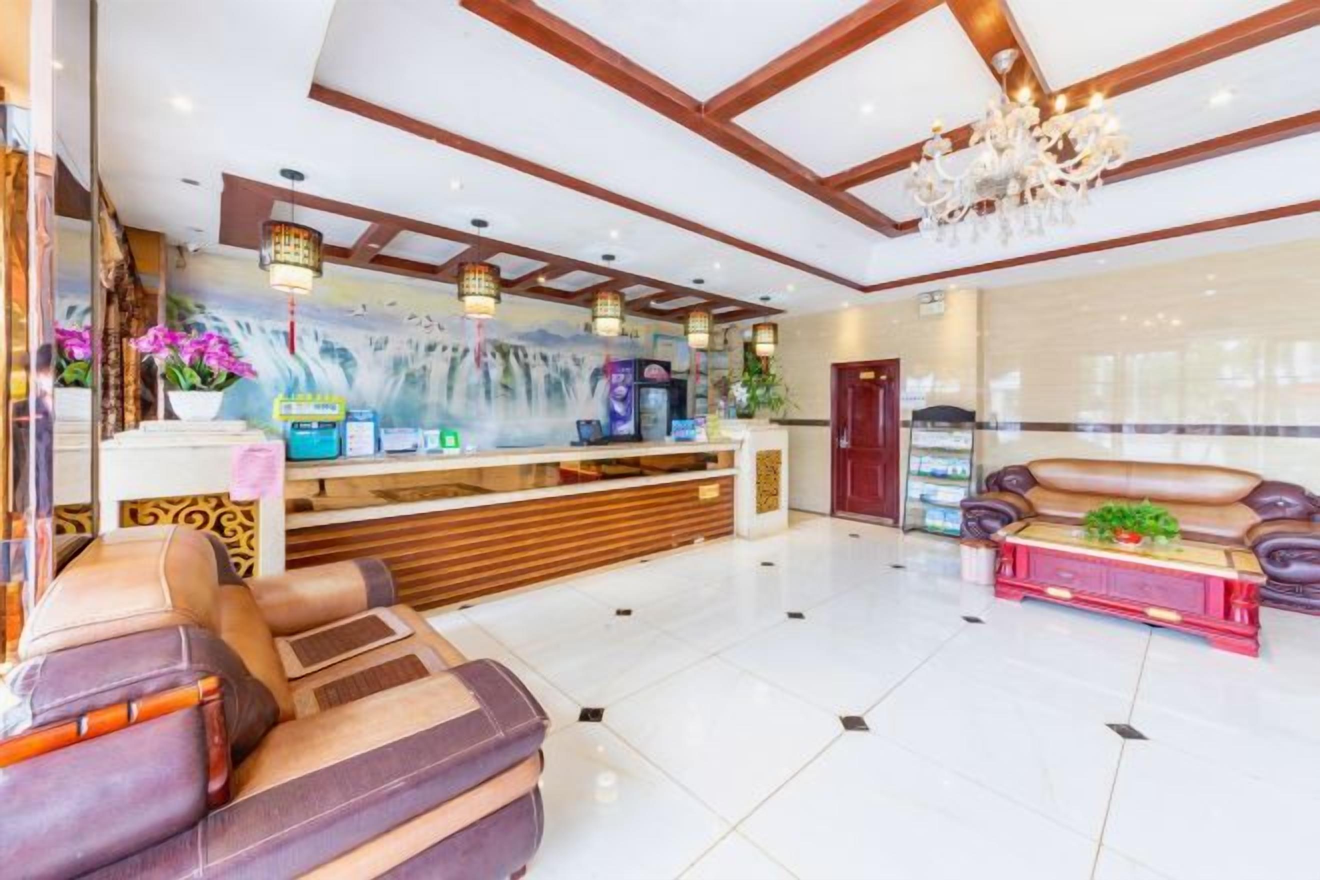 A reception area with a reception desk, seating area, and a chandelier.