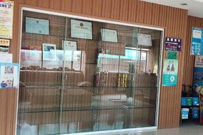 A reception area with a glass partition, various informational signs, and a bulletin board. - Ce Heng Hengjie Business Hotel (Ceheng)