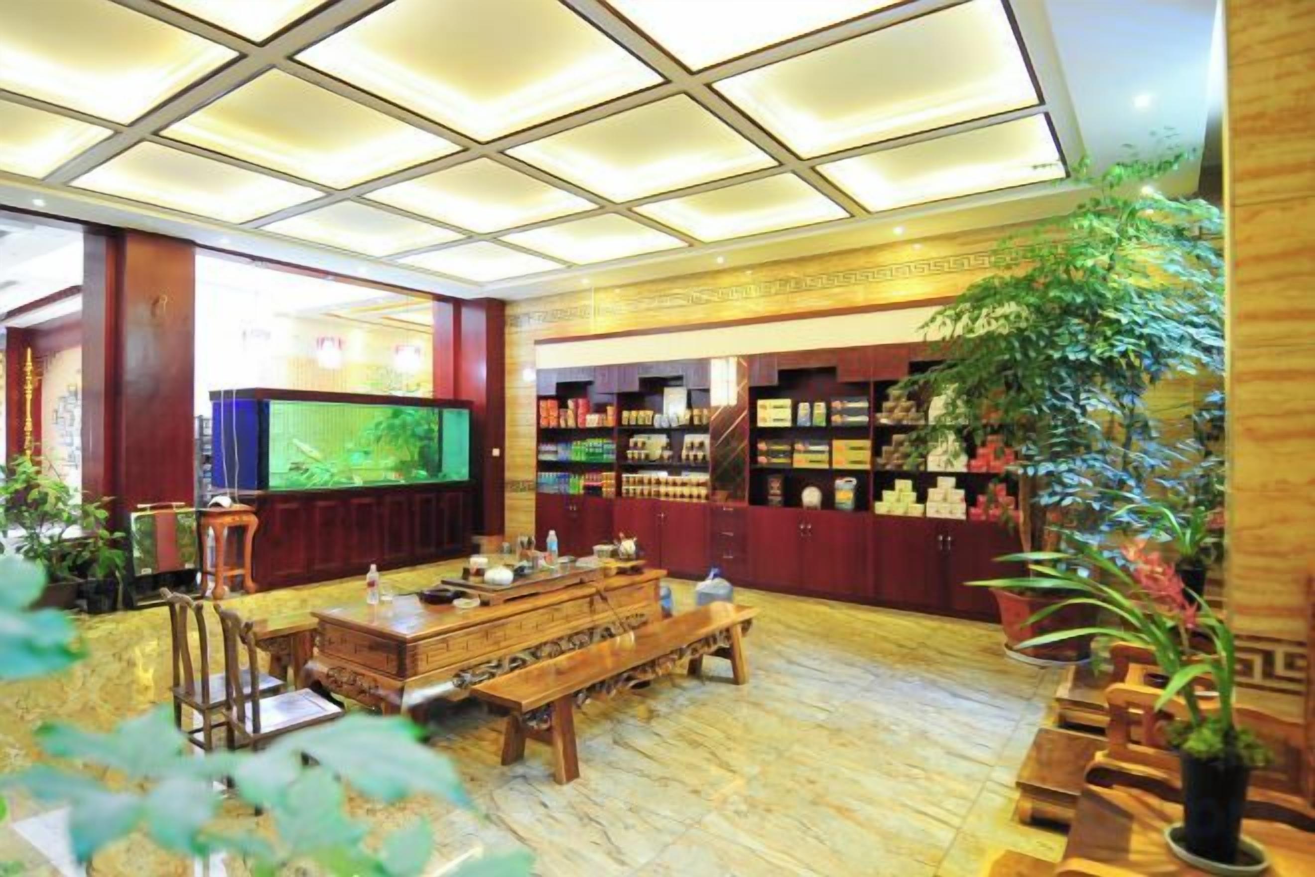 A hotel lobby with a wooden bench, a television, and a display of items.