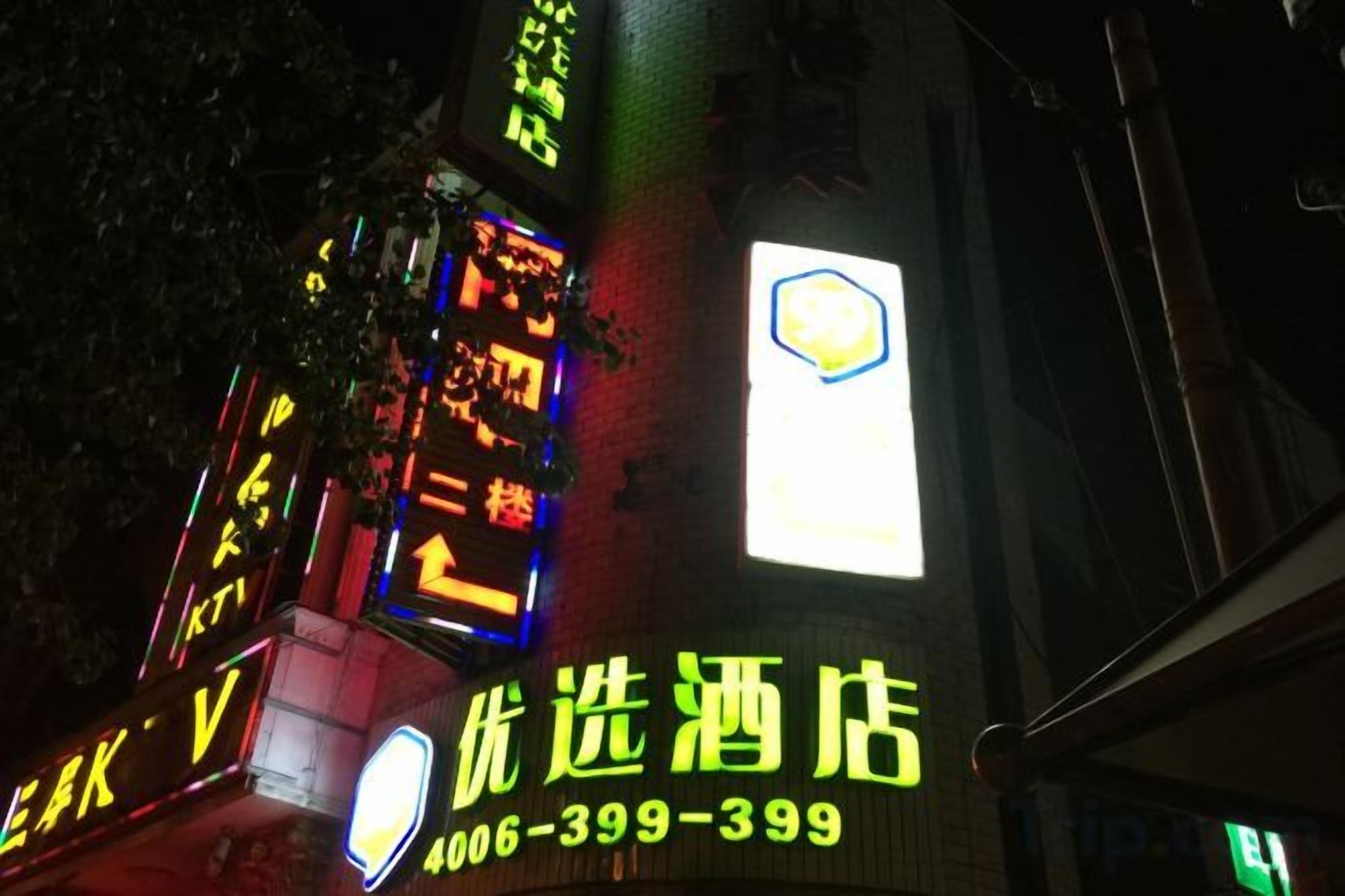 A building with illuminated signage, including a prominent hotel sign and various directional arrows.