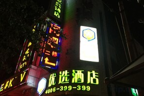 A building with illuminated signage, including a prominent hotel sign and various directional arrows. - 99inn Selected (Beijing South Station Jiaomendong Metro Station) (Beijing)