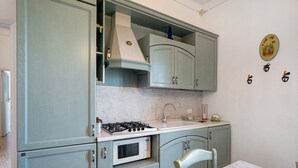 A kitchen with a stove, microwave, sink, and cabinets.