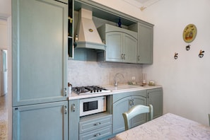 Une cuisine équipée d’une cuisinière, d’un four à micro-ondes, d’un évier et de placards.
