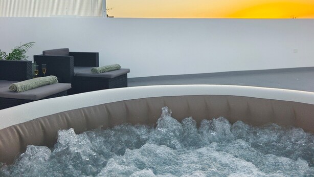 A hot tub with water, a seating area with cushions, and a view of the sunset. - Vacation Home 'El Rinconcito De Niña' with Sea View, Private Terrace and Wi-Fi (Tijoco Bajo)
