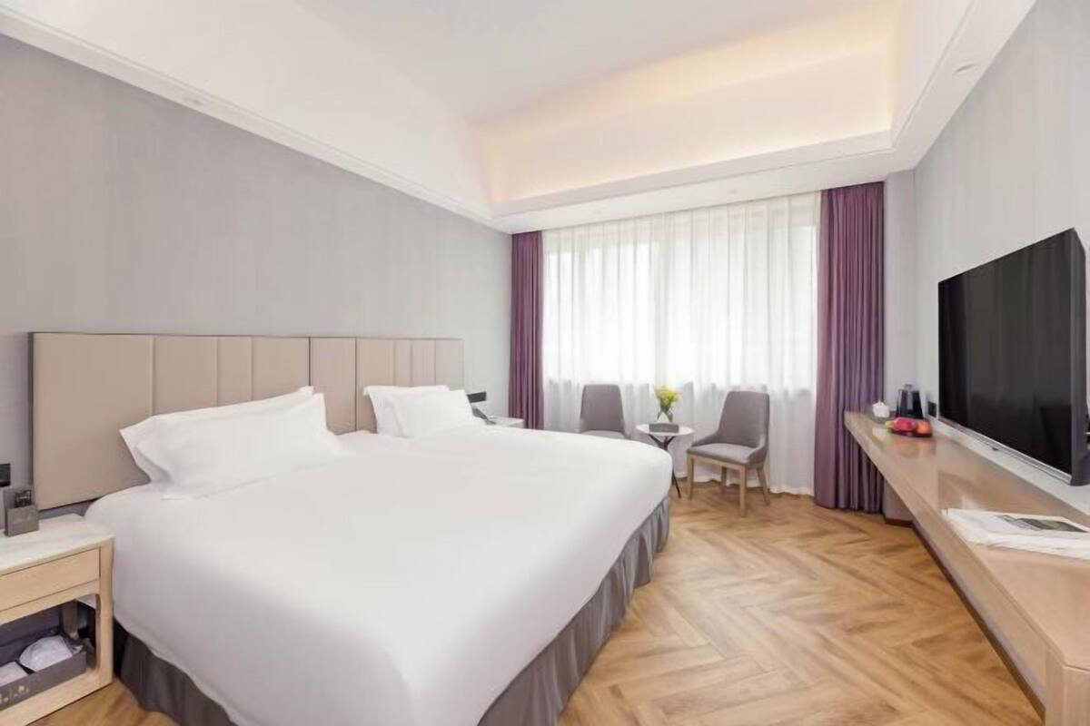 Une chambre d’hôtel avec un lit, une télévision, un bureau et une chaise.