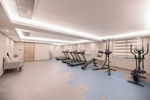 A gym with treadmills, stationary bikes, and a weight machine. - Tianhe Hotel (Guangzhou)