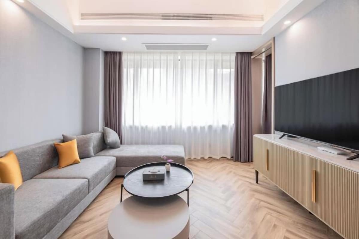 A modern living room with a sofa, a coffee table, a TV, and a cabinet.