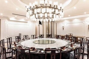 A round table with chairs, a chandelier, and a glass-top table. - Tianhe Hotel (Guangzhou)