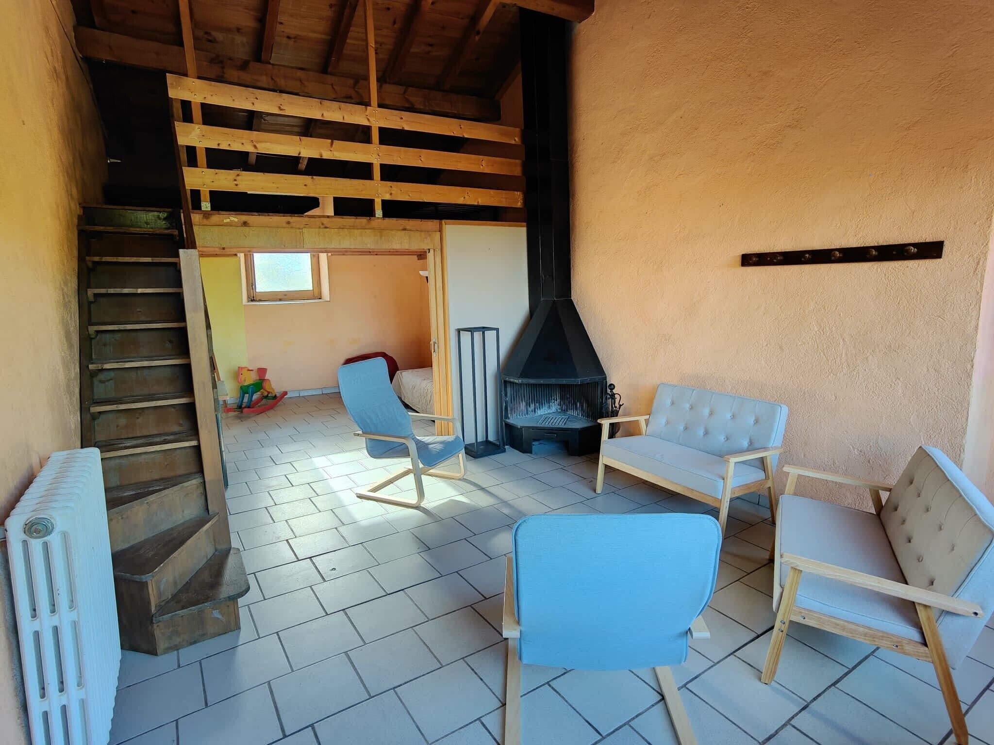 Une pièce chaleureuse avec une cheminée, des meubles en bois et un escalier.