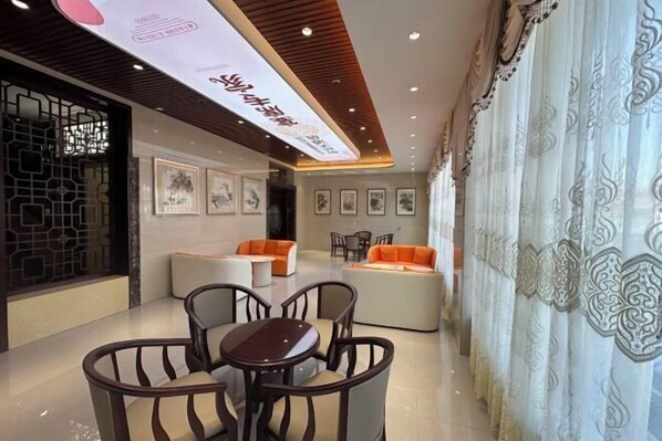 Un interior moderno con comedor, sofás y cuadros en las paredes.