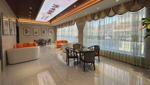 A modern hotel lobby with a polished floor, comfortable seating, and large windows with sheer curtains. - Donggang Yuyun Hotel (Donggang)