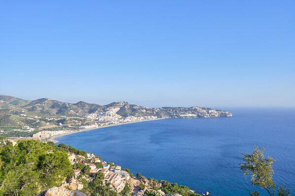 A coastal landscape with a clear view of the sea, a hilly terrain, and a small settlement with buildings. - Holiday Home 'Los Altos 23' with Sea View, Wi-Fi and Air Conditioning (Almuñécar)