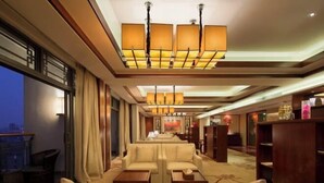 A hotel lobby with a sofa, tables, and a chandelier. - Ji'an Hotel (Ji'an)