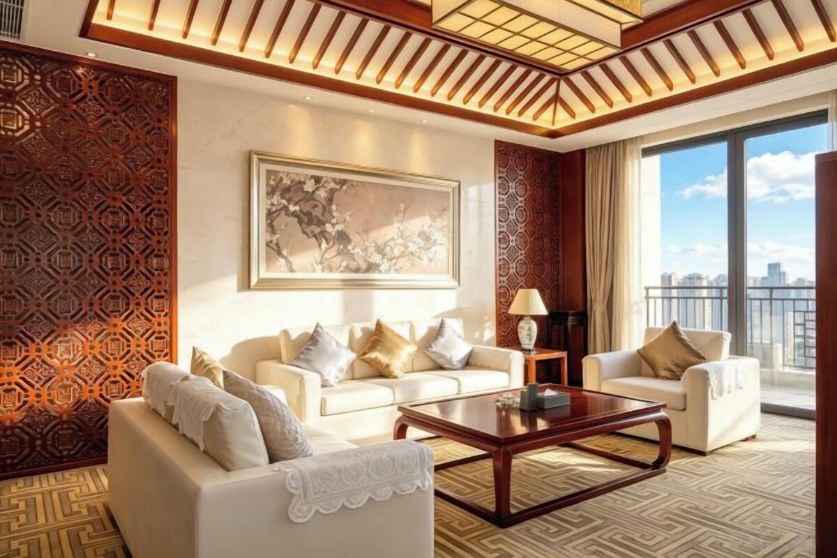 A modern living room with a sofa set, a coffee table, and a large window with a city view.